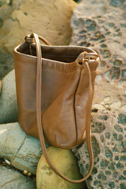 Brown leather handbag on a textured stone surface