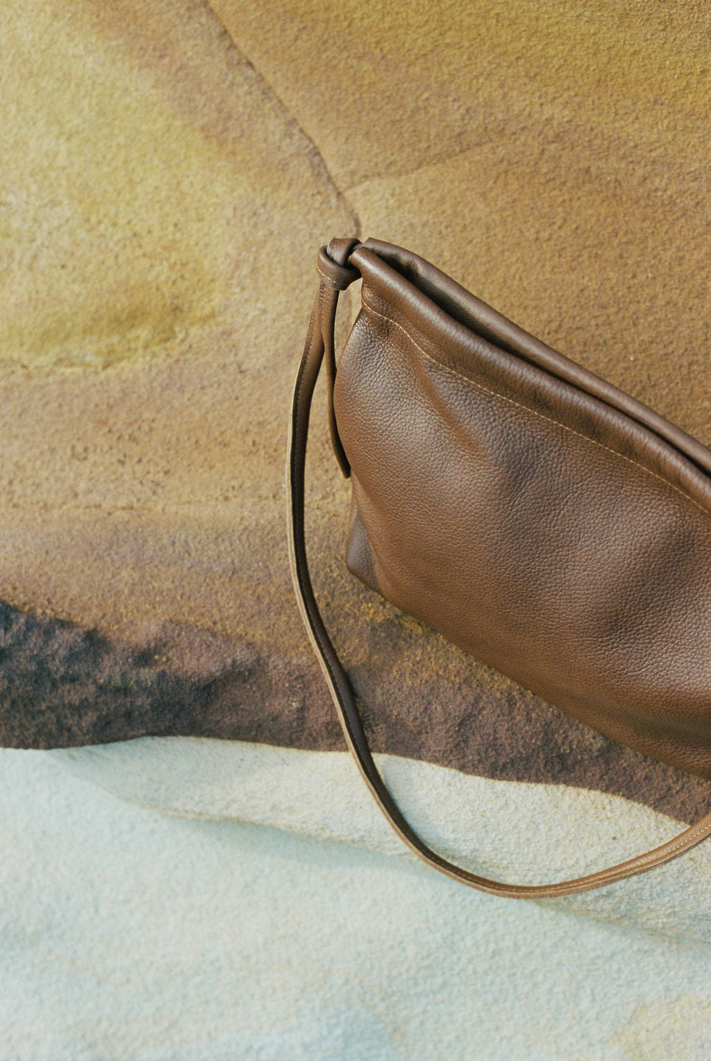 Brown leather handbag on a textured surface